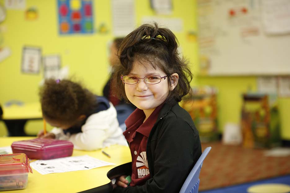 student in classroom smiling at camera